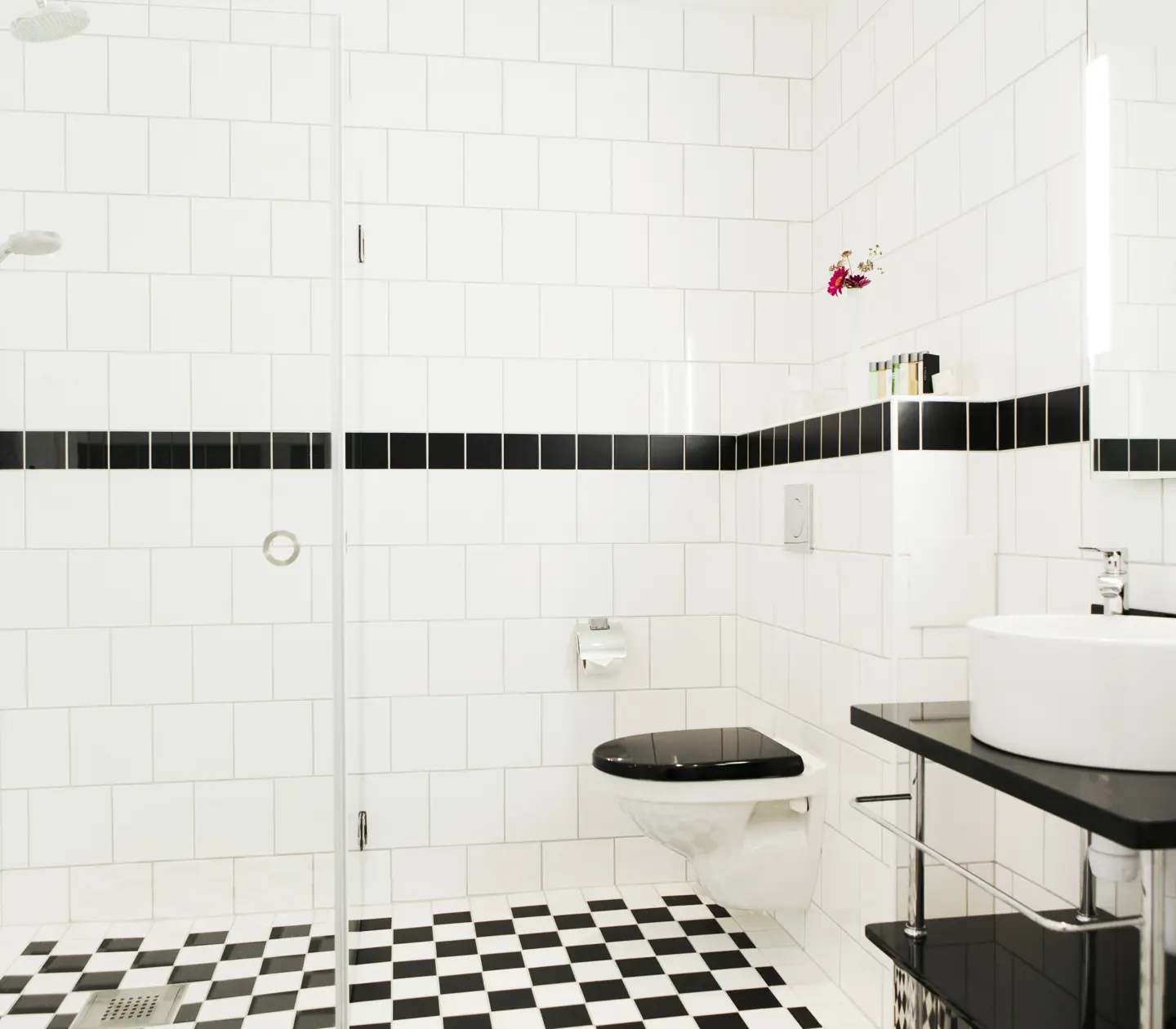 Ljust badrum med handfat, toalett och dusch