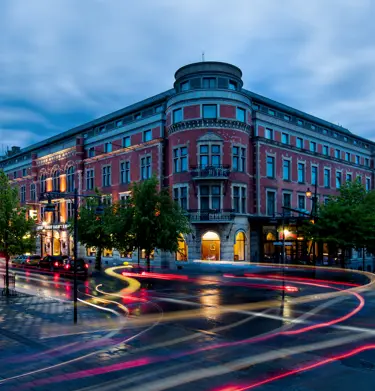 Elite Stadshotellet i skymning och trafikbelysning utanför