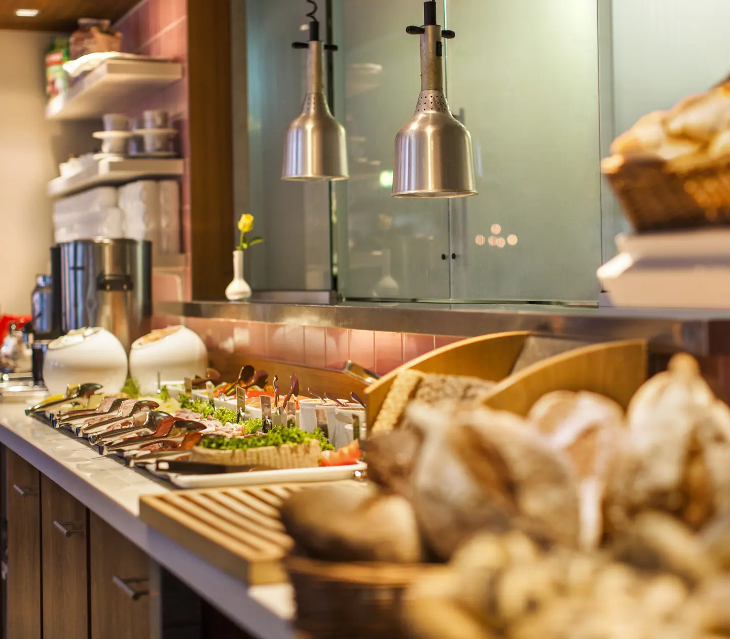 Frukostbuffé uppdukad på bord Hotellobby med receptionsdisk, kristallkrona och pelare