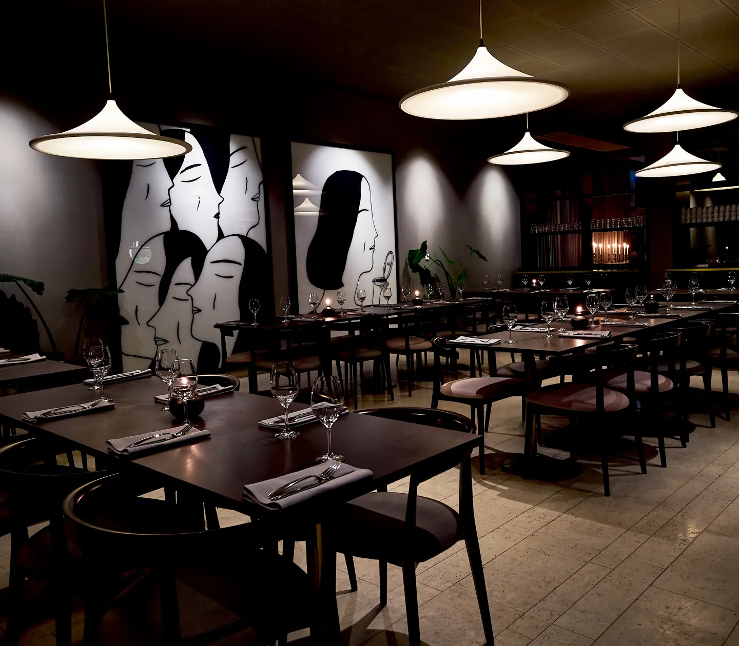 Restaurangmiljö med matgrupper, lampor och stora målningar