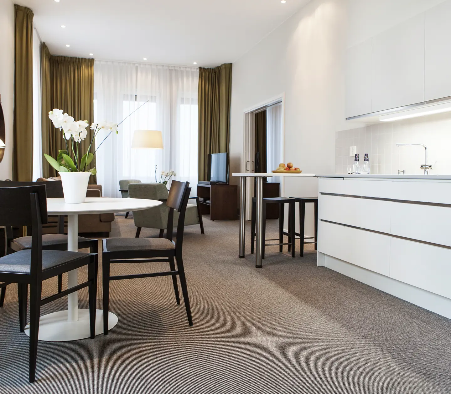 Ljus svit med matgrupp, soffgrupp och köksbänk