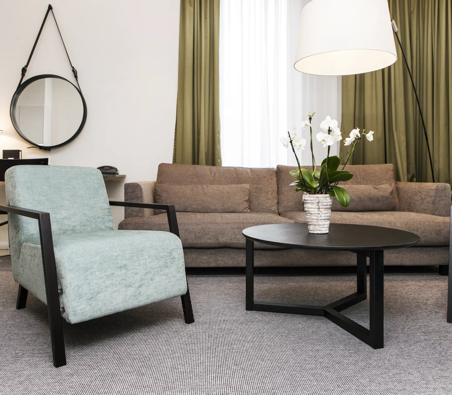 Ljus svit med skrivbord, soffgrupp och fönster