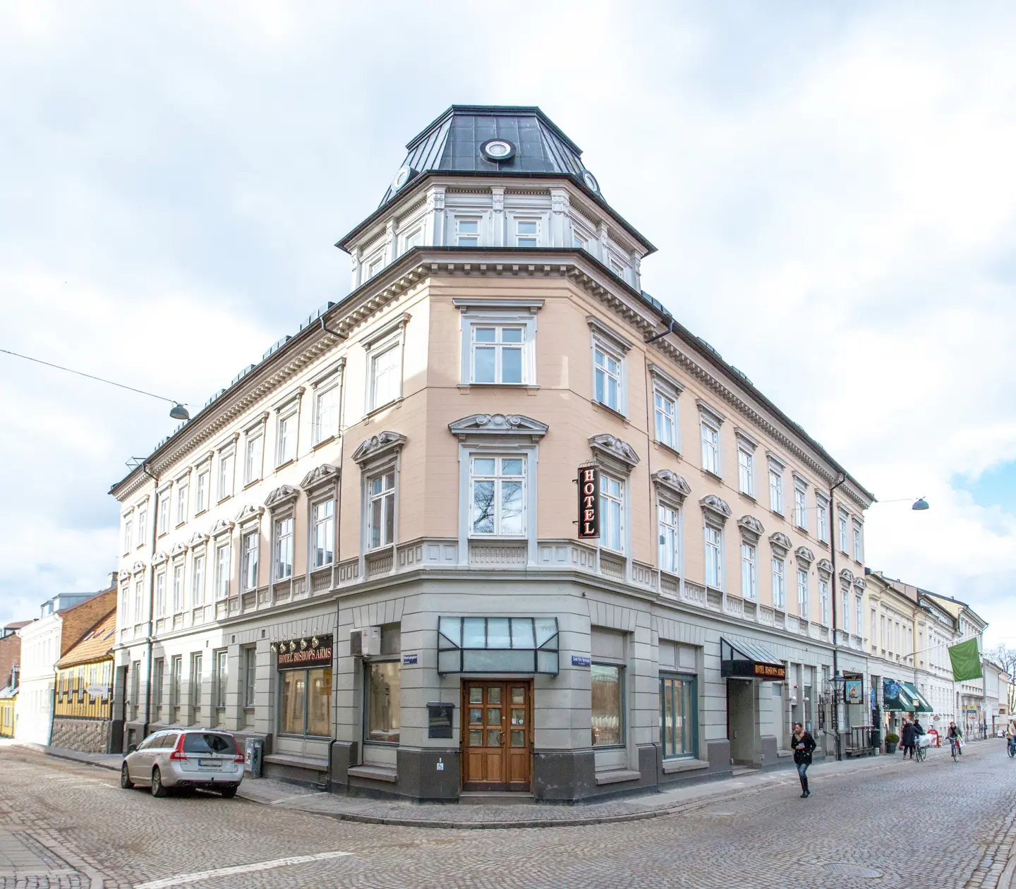 Fasaden av Hotel Bishops Arms med gågata och bilar framför