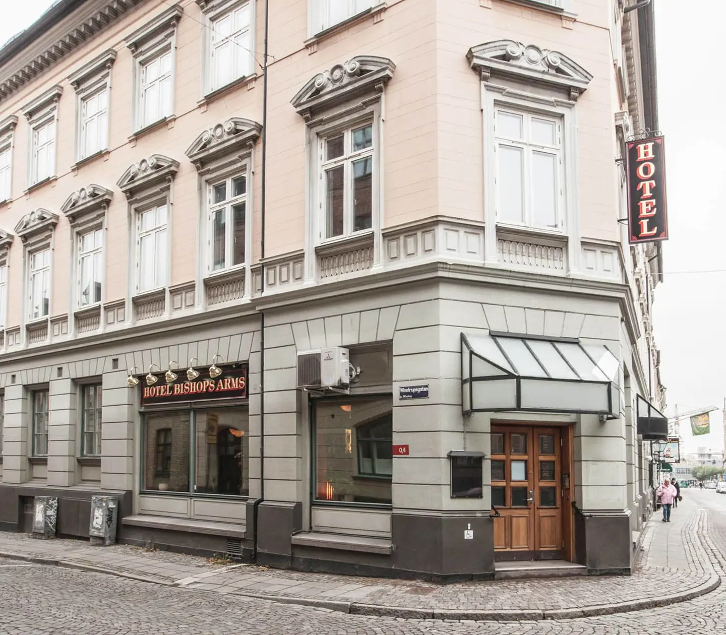 Fasaden av Hotel Bishops Arms med skyltar utanför och många fönster