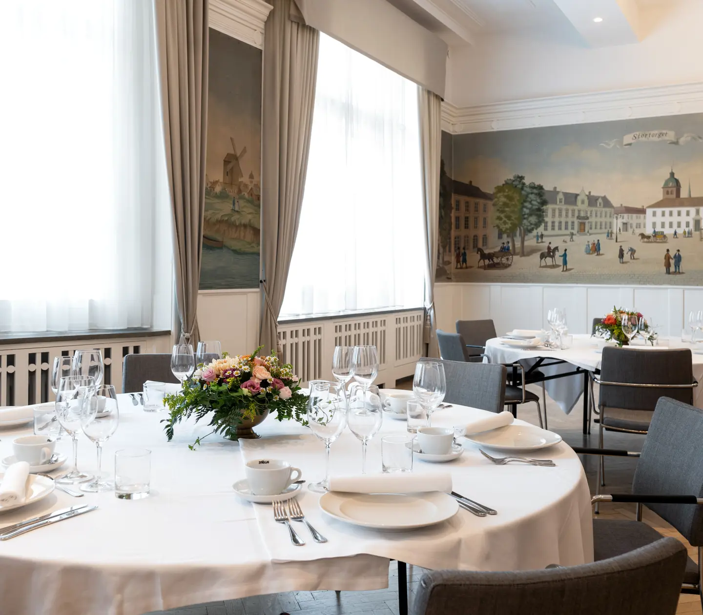 Lokal med fina målningar och dukade runda bord
