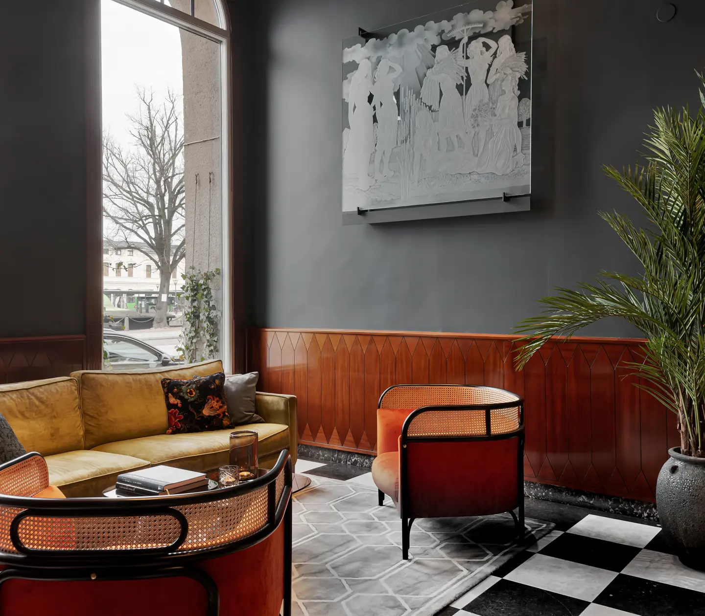 Fin hotellobby med soffgrupp, krukväxter och fönster