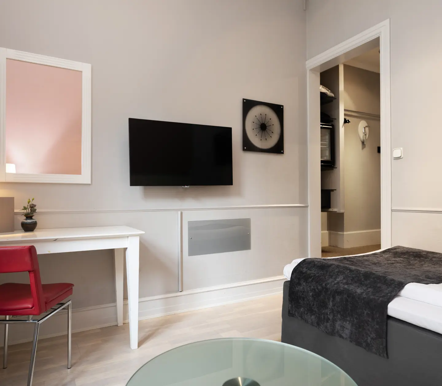 Hotellrum med enkelsäng, skrivbord och tv