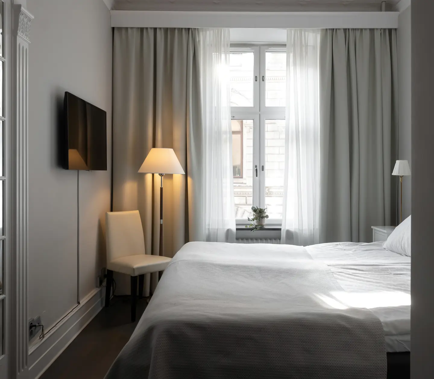 Hotellrum med dubbelsäng, spegel och fönster