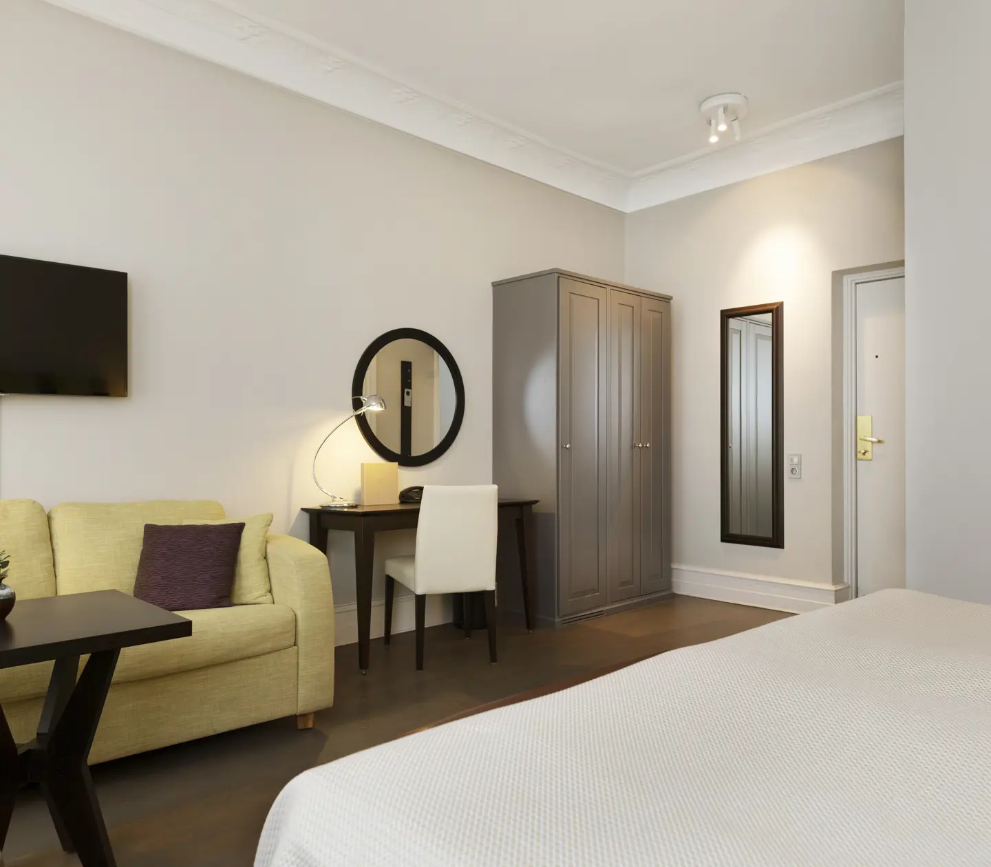 Hotellrum med soffa, skrivbord och garderob