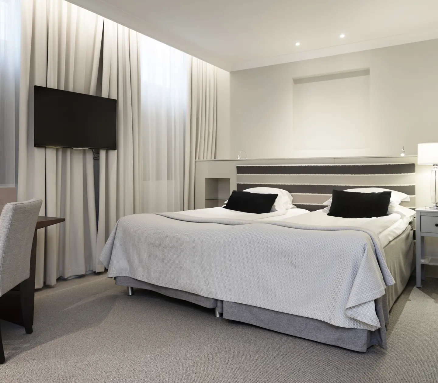 Hotellrum med dubbelsäng, skrivbord och tv