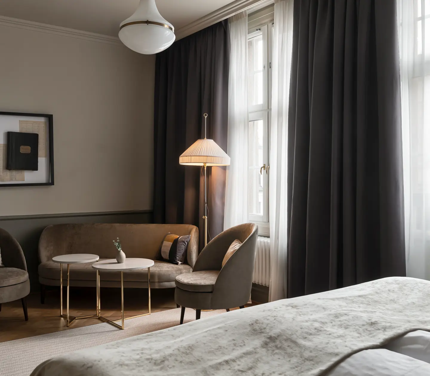 Mysigt hotellrum med soffgrupp, golvlampa och gardiner
