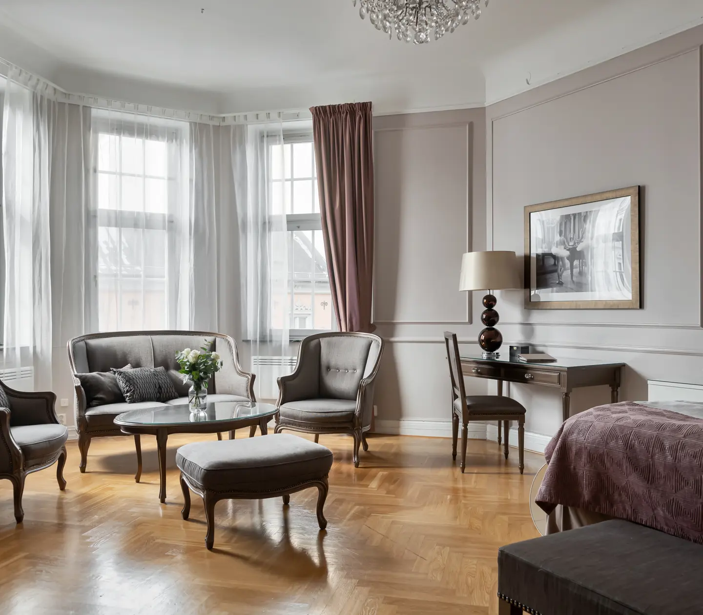 Hotellrum med soffgrupp, skrivbord och fönster