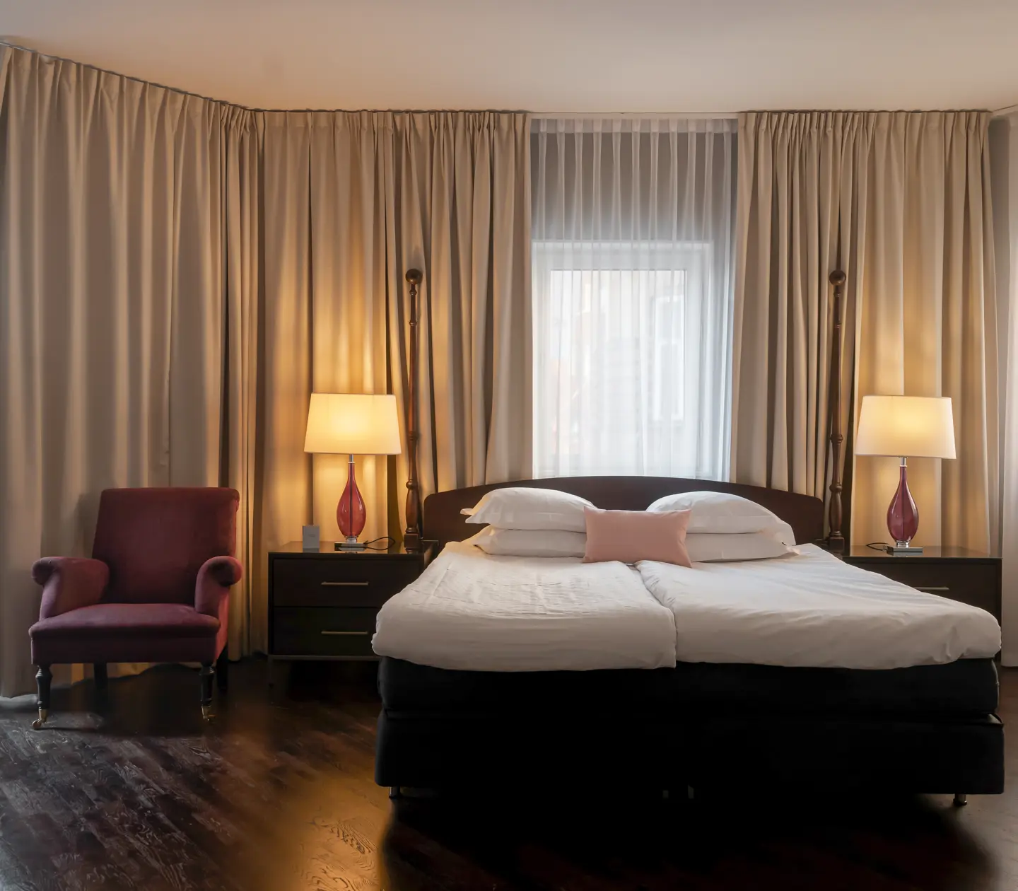 Mysigt hotellrum med säng, fönster och gardiner