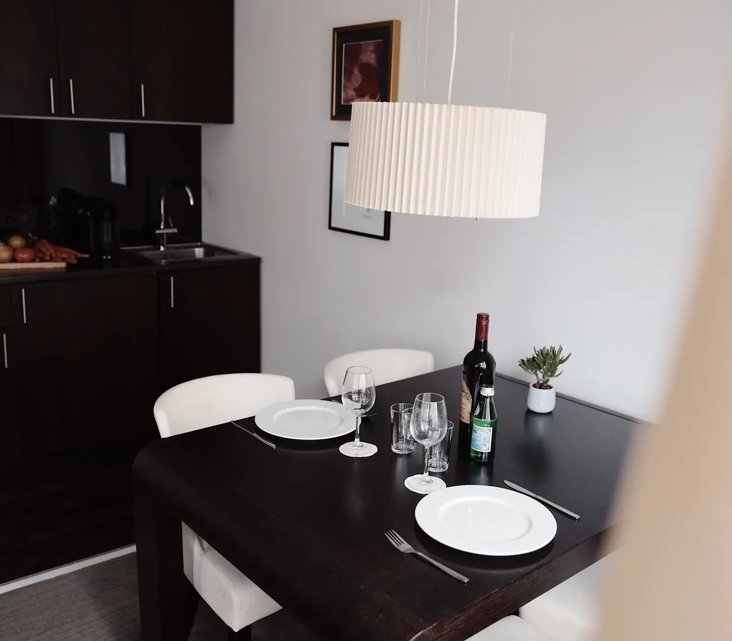Ljus svit med köksbänk, matgrupp och taklampa