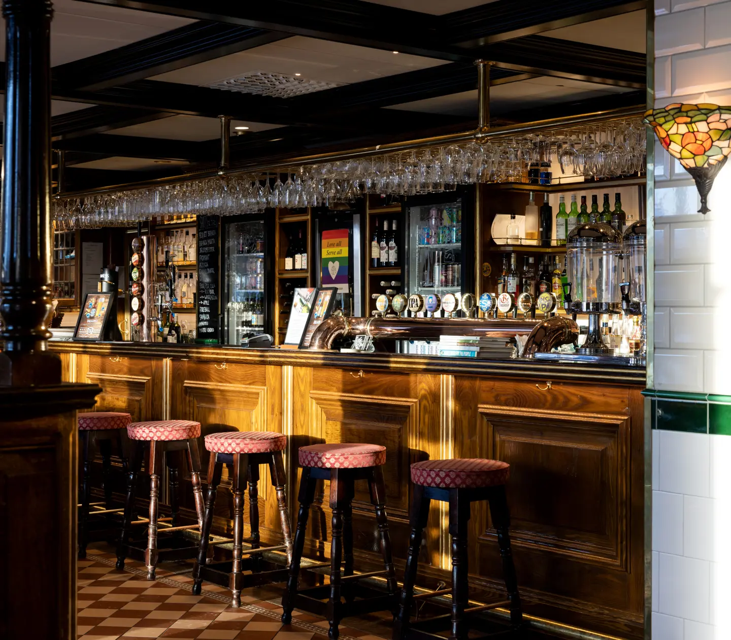 Pubmiljö med barstolar, bar och flaskor