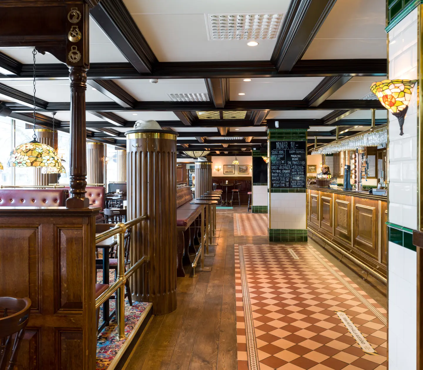 Pubmiljö med sittplatser, bar och menyer på svarta tavlor