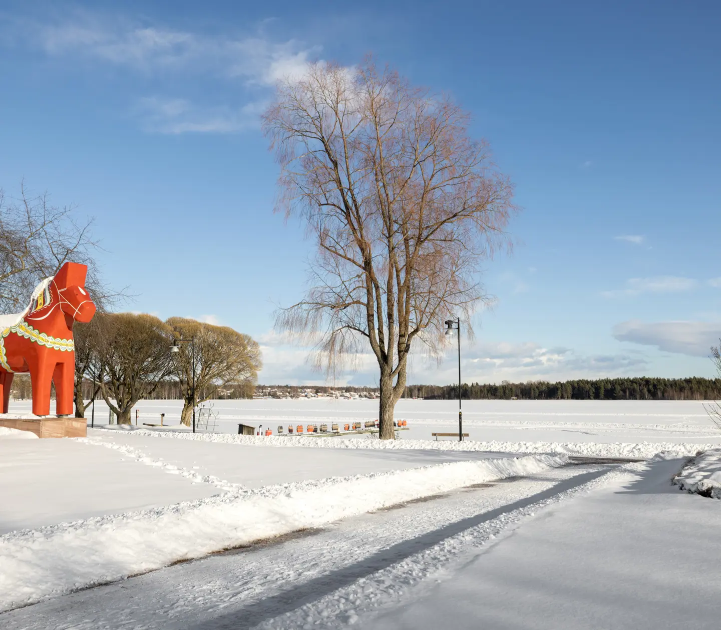 Centrala Mora täckt i snö med stor Dalahäst och utsikt över Siljan