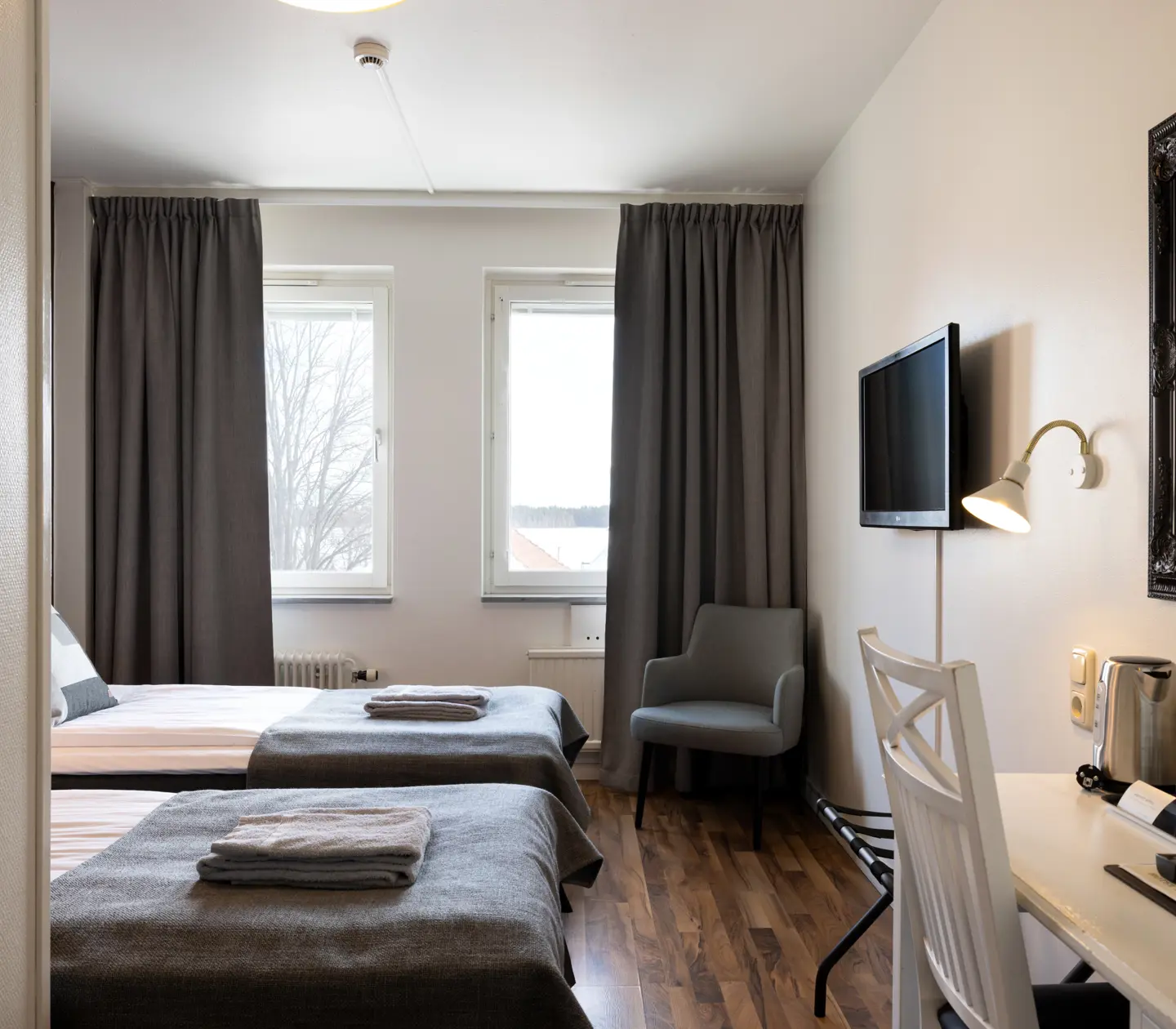 Hotellrum med sängar, skrivbord och fönster
