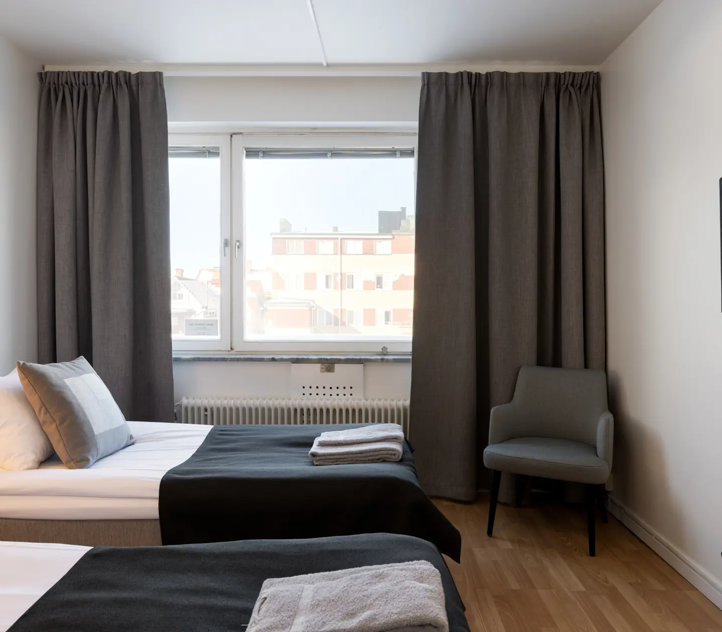 Hotellrum med sängar, sänggavel i trä och tv