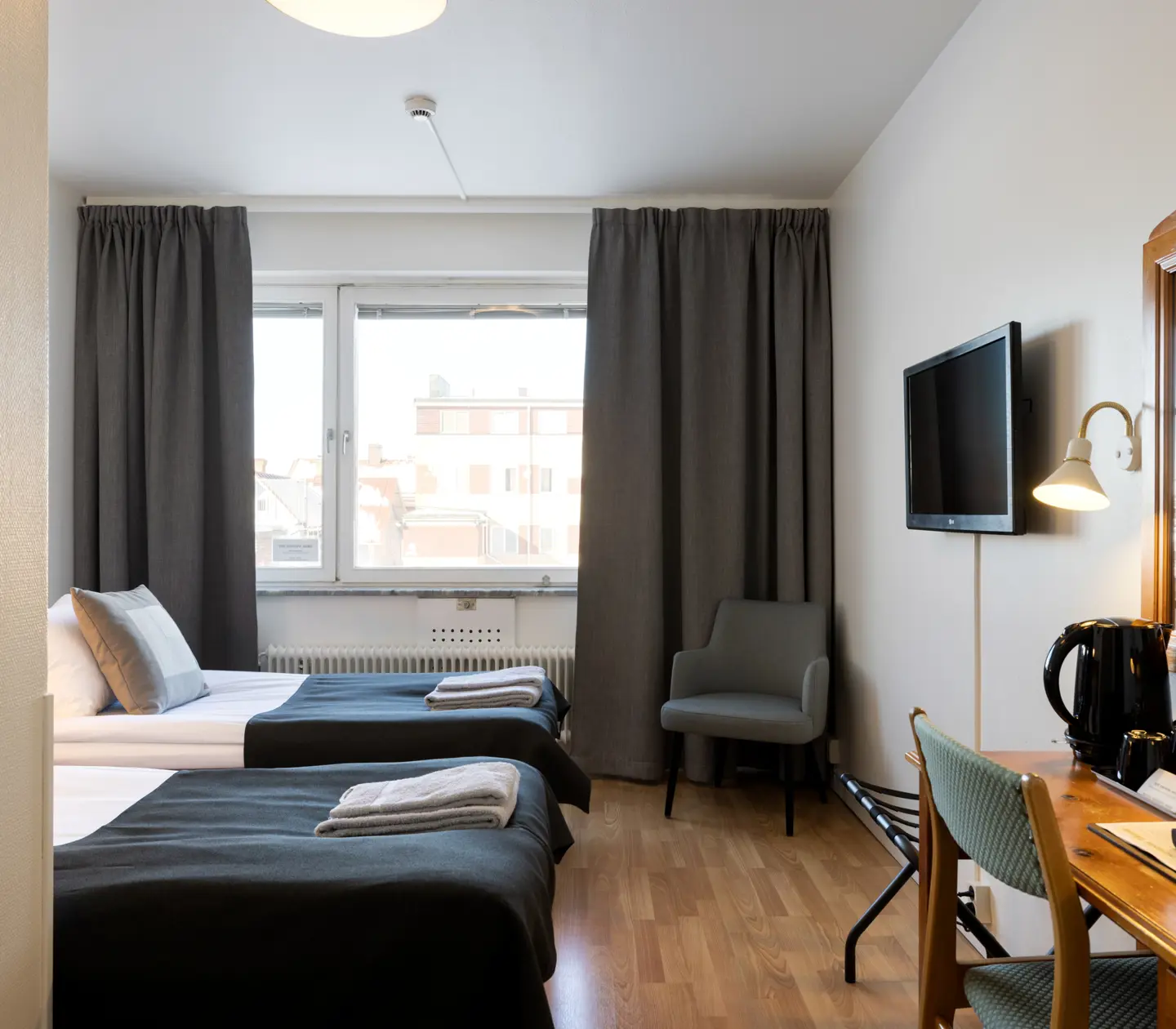 Hotellrum med sängar, skrivbord och fönster