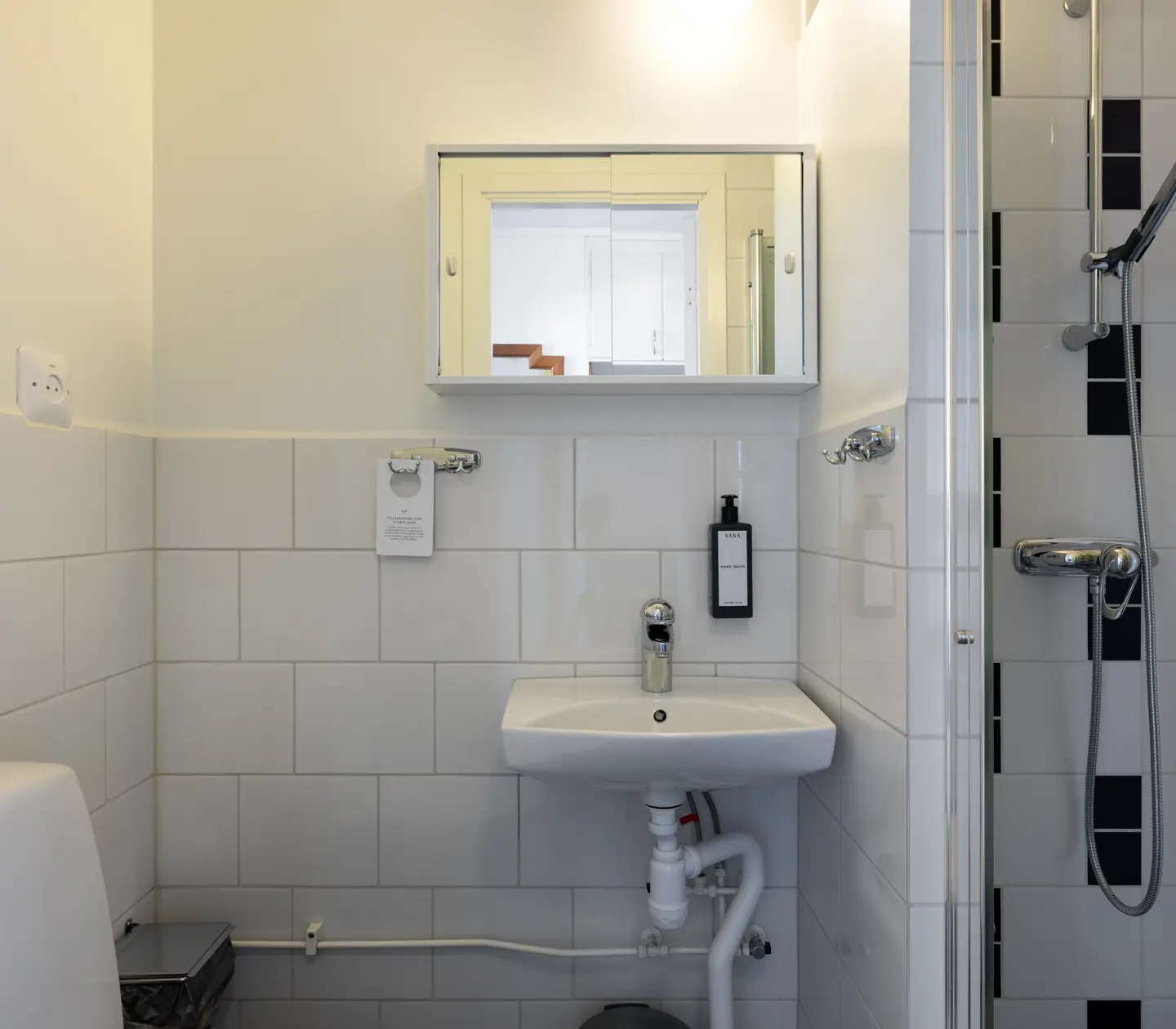 Ljust badrum med toalett, handfat och dusch