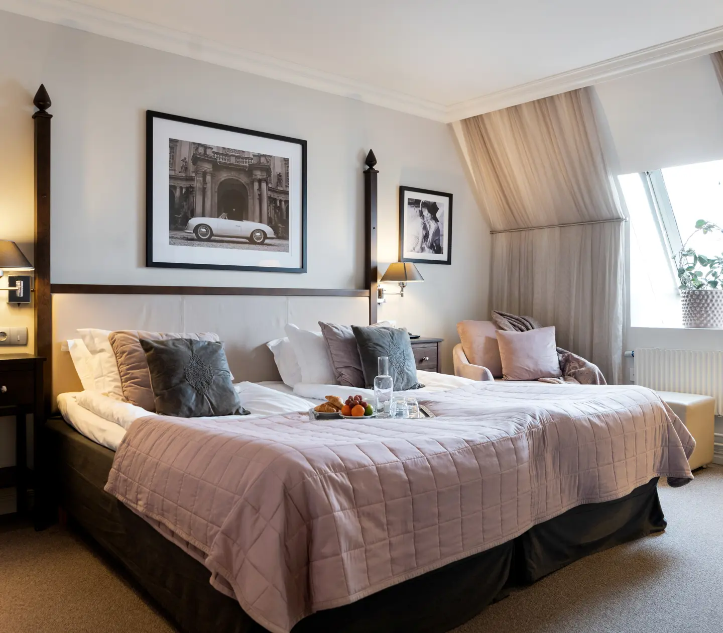 Hotellrum med stor säng, fåtölj och snedtak