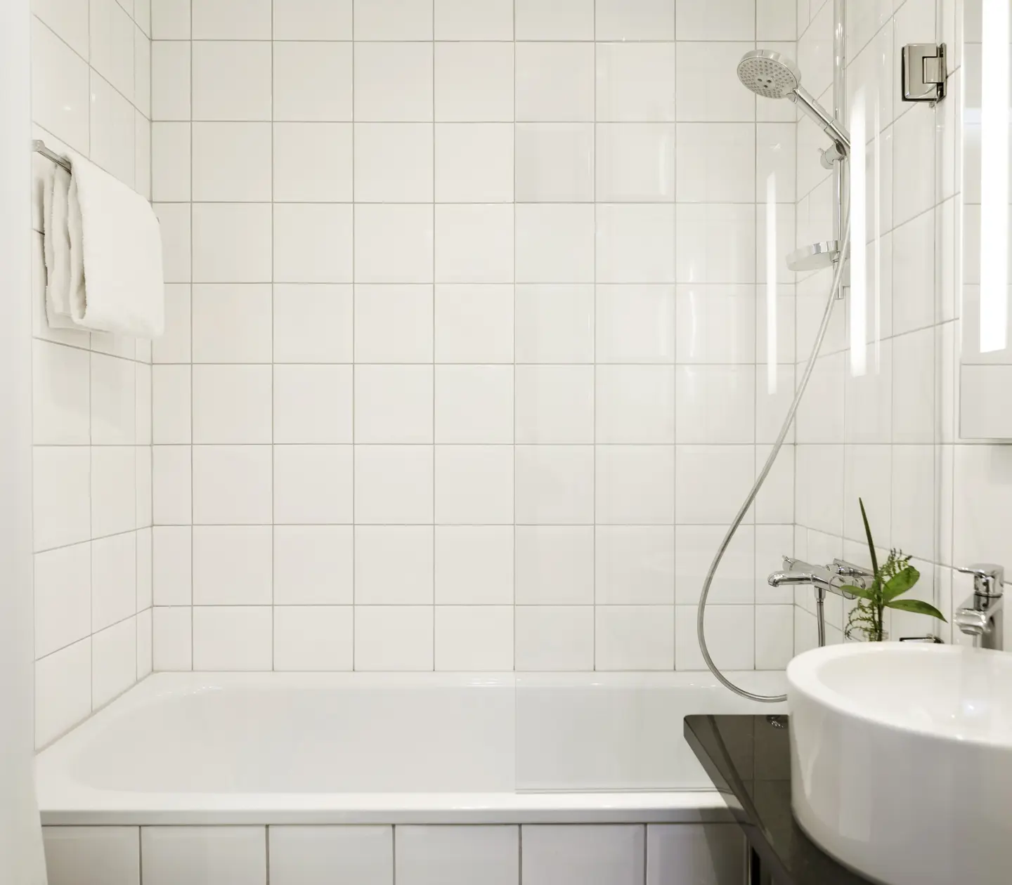 Ljust badrum med handfat, spegel och badkar