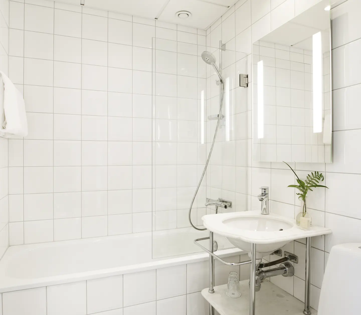 Ljust badrum med handfat, spegel och badkar