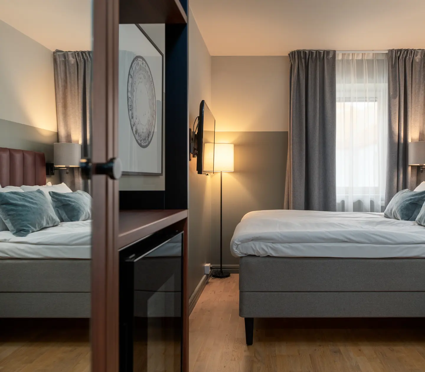 Ombonat hotellrum med dubbelsäng, spegel och fönster