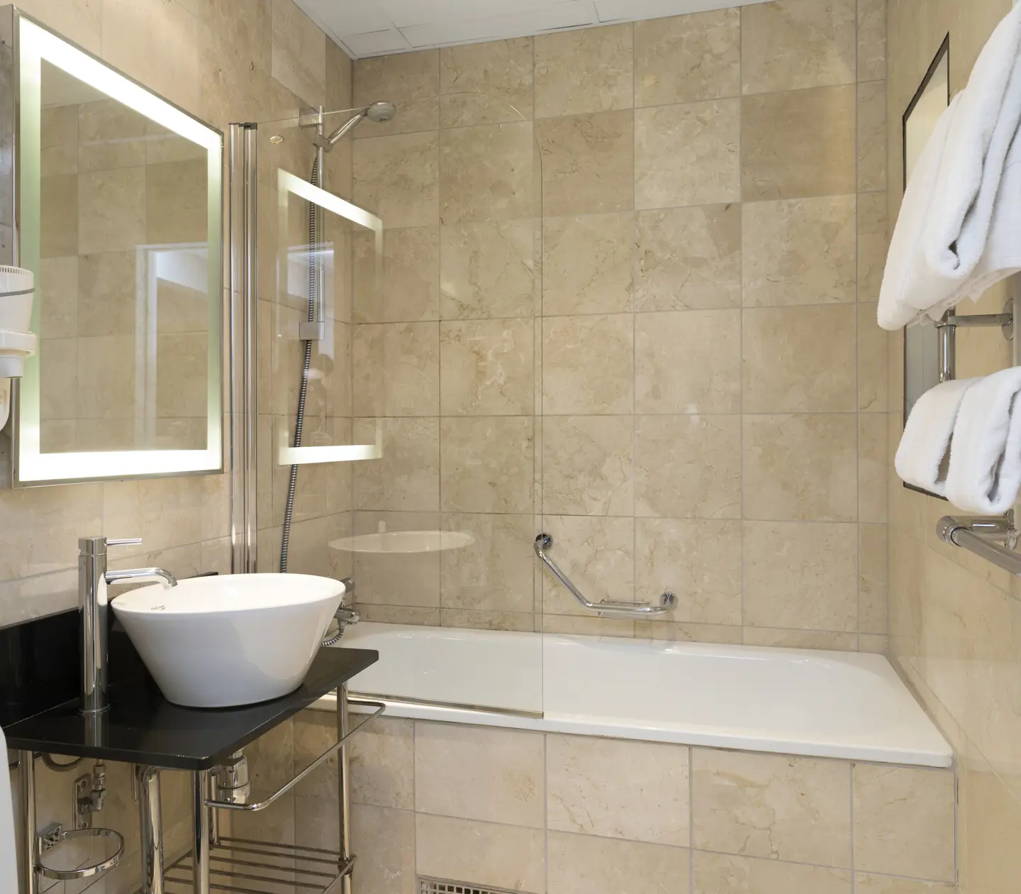 Beige badrum med badkar, handfat och spegel