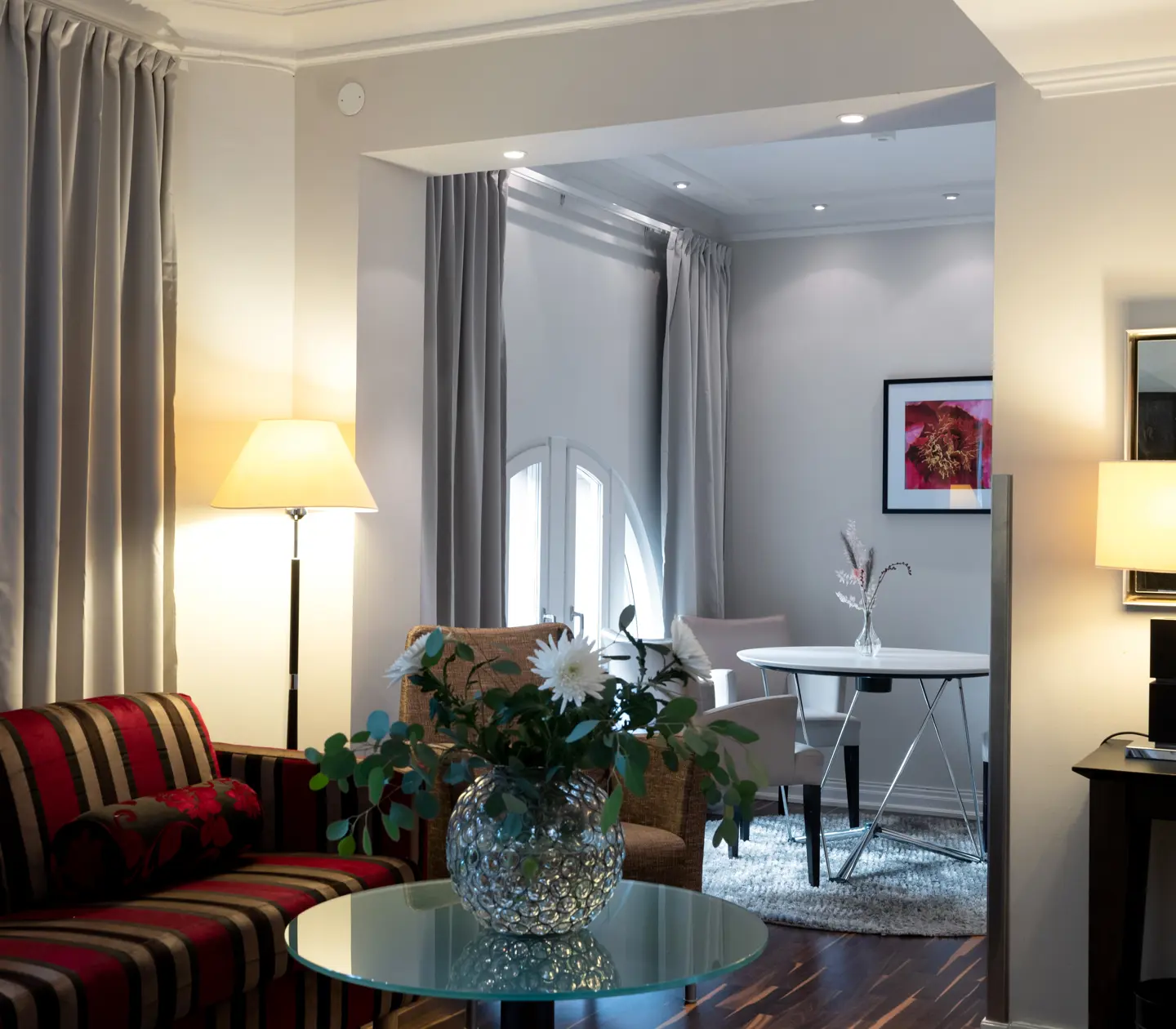 Hotellrum med matbord, bukett och soffa
