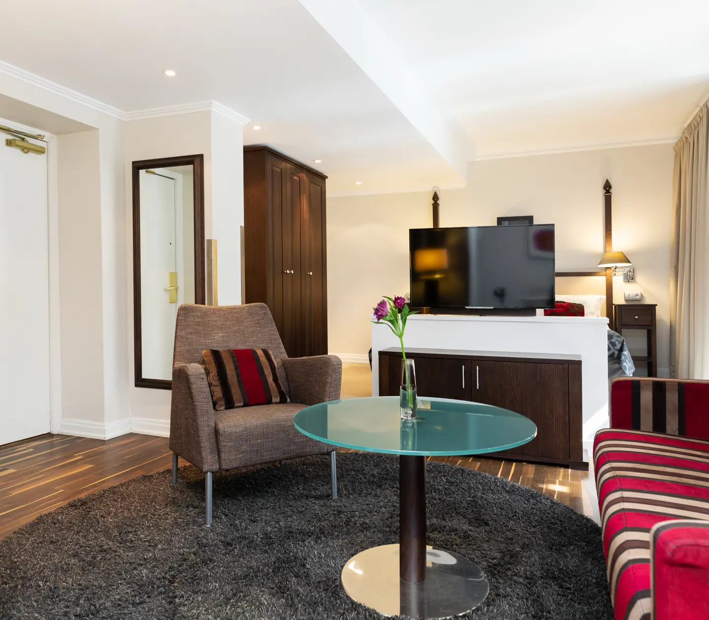 Hotellrum med soffgrupp, tv och garderob