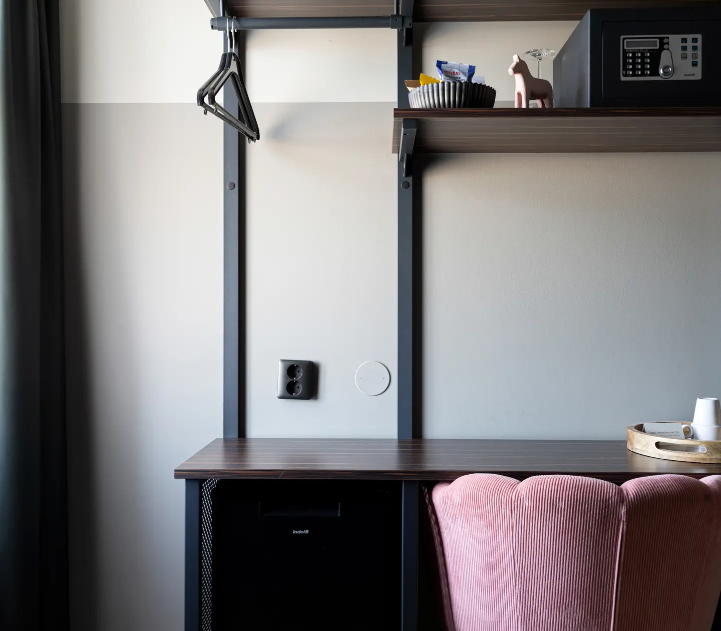 Fint enkelrum med skrivbord, värdeskåp och rosa fåtölj