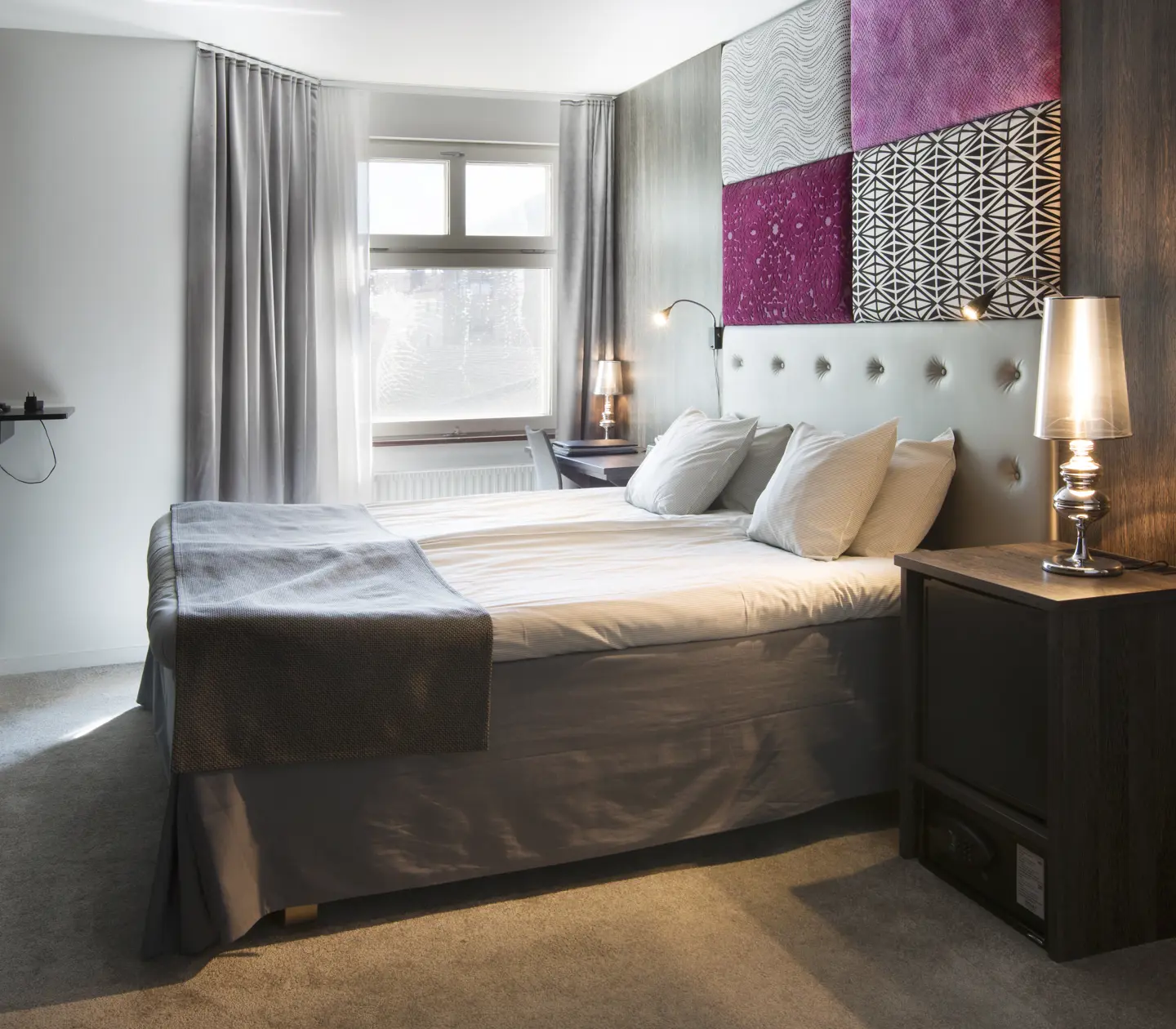 Hotellrum med dubbelsäng, tv och fönster