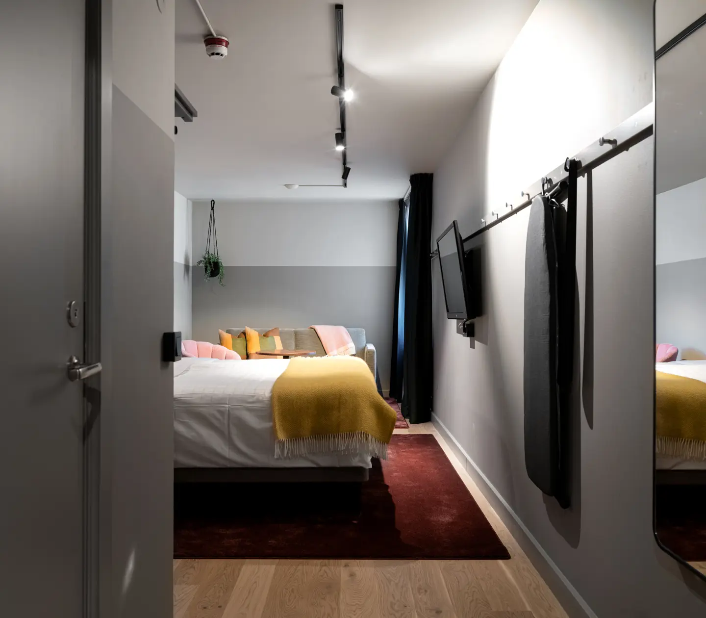 Hotellrum med spegel, dubbelsäng och tv