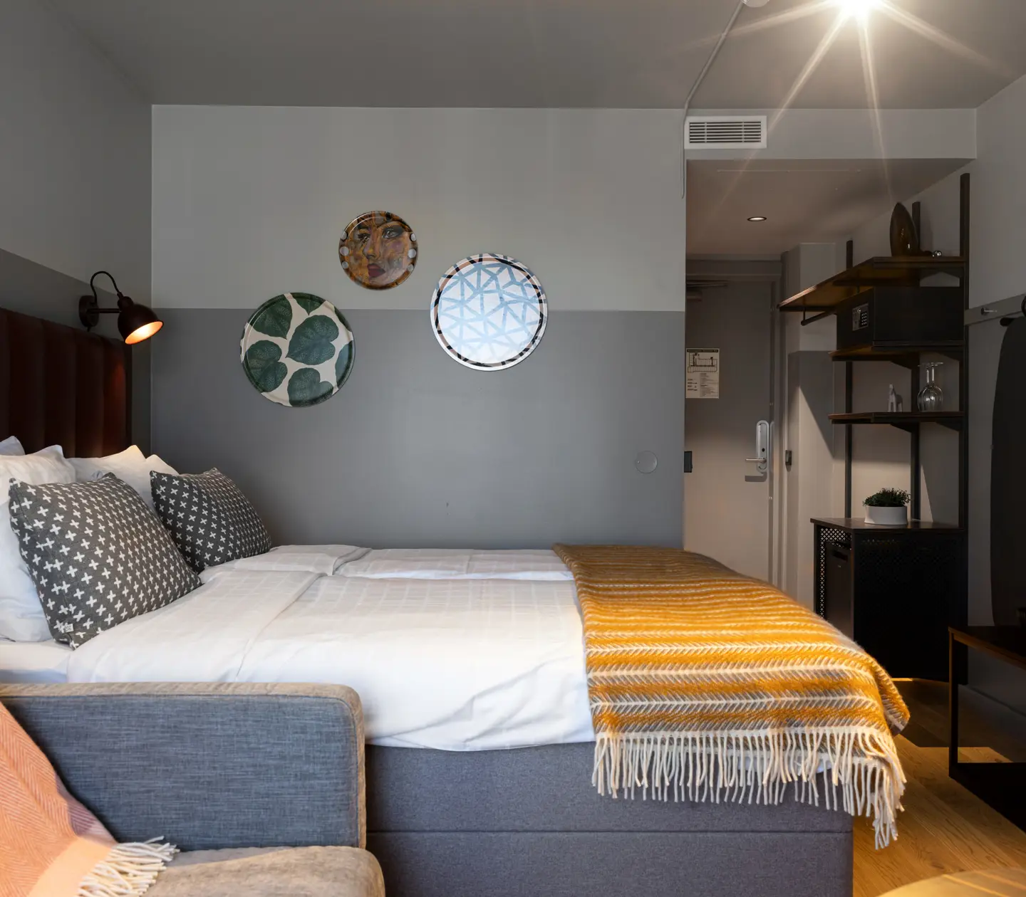 Hotellrum med dubbelsäng, tavlor och garderob