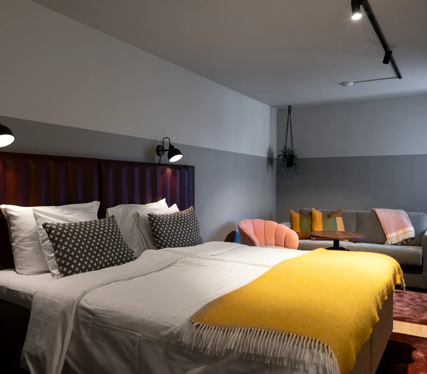 Ombonat hotellrum med dubbelsäng och soffgrupp