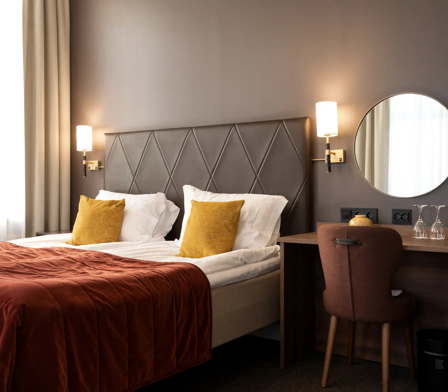 Hotellrum med dubbelsäng, skrivbord och spegel