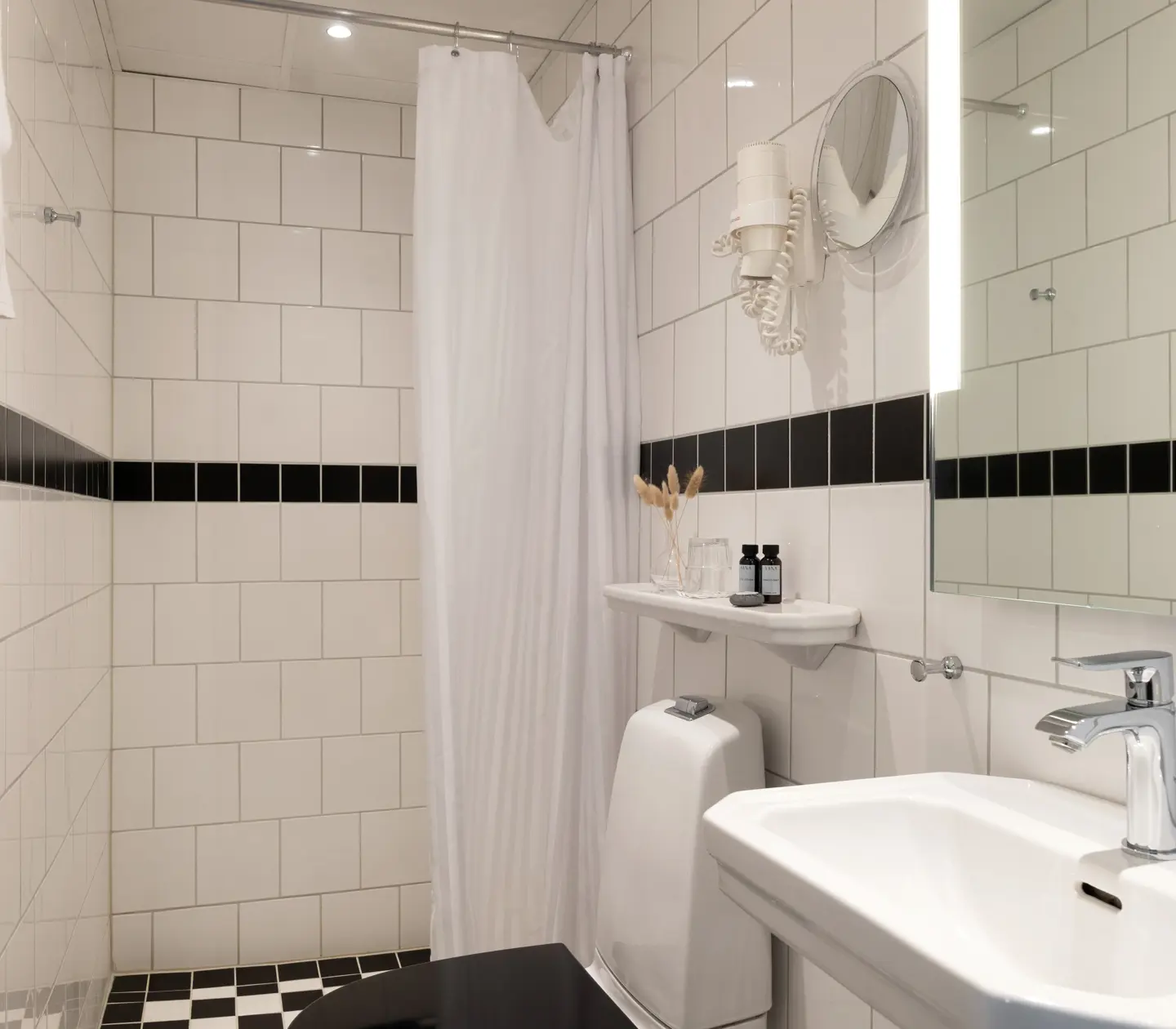 Ljust badrum med handfat, toalett och dusch