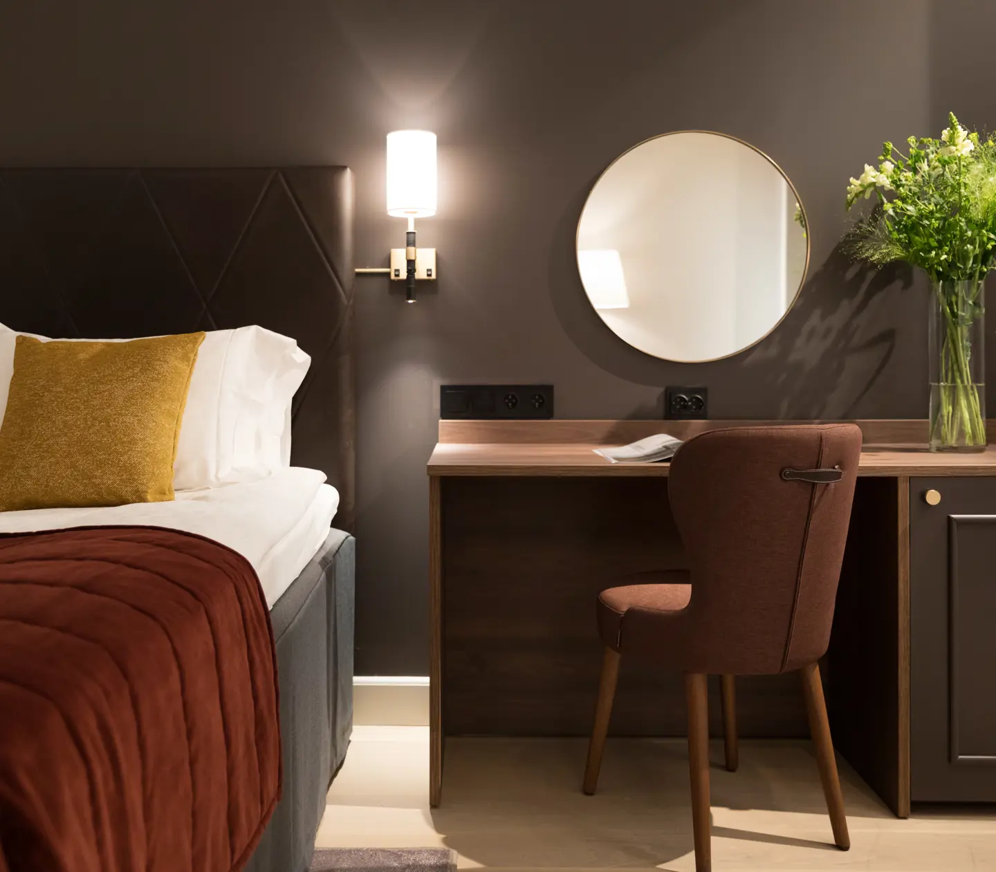 Hotellrum med säng, skrivbord och spegel