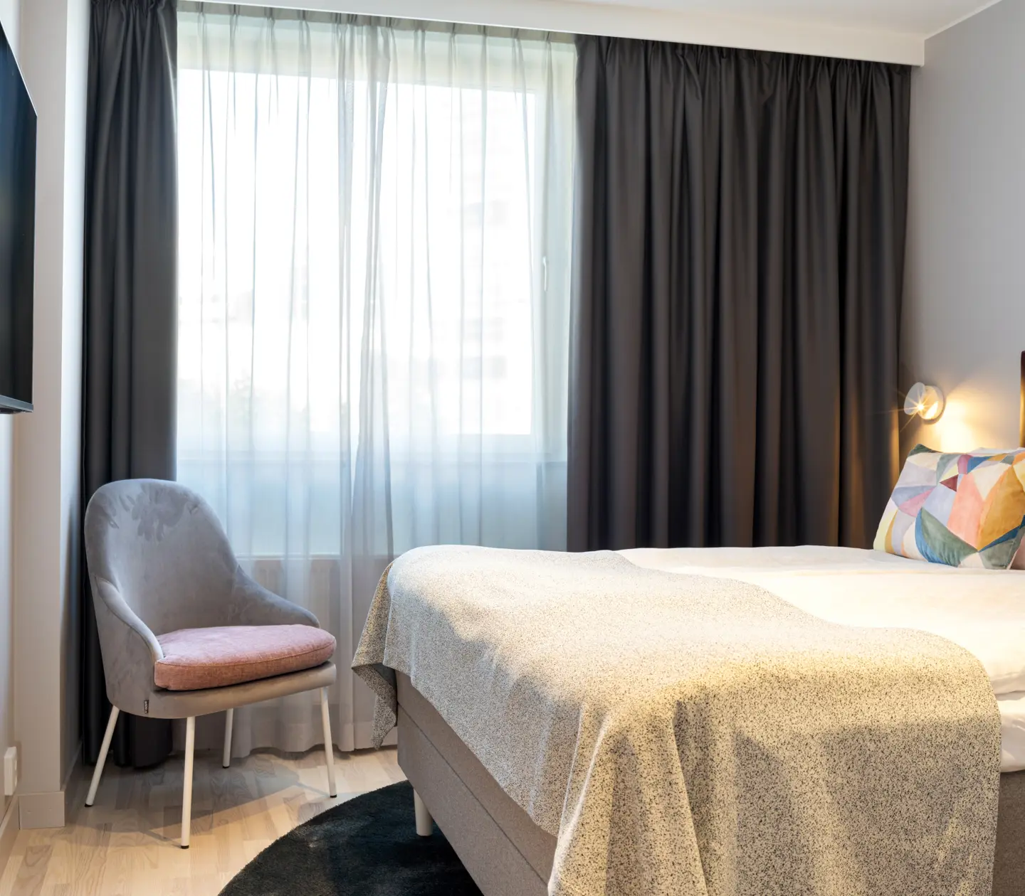 Fint hotellrum med dubbelsäng, tv och fönster