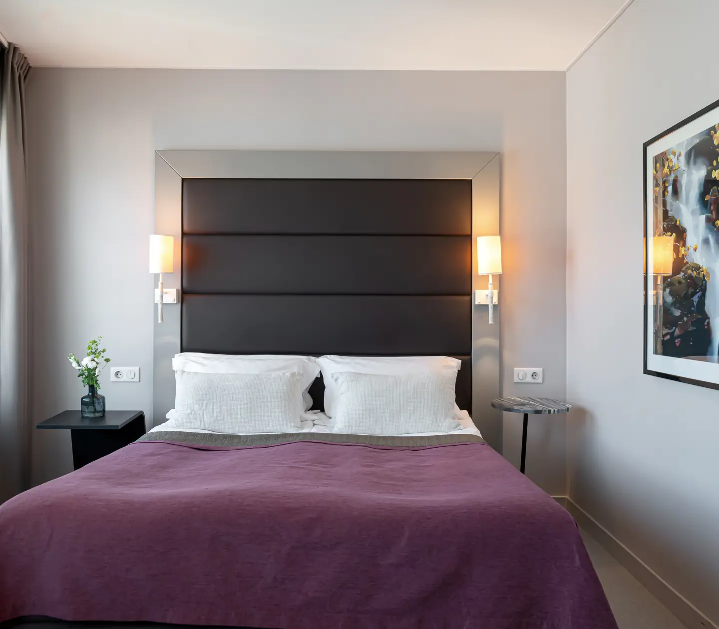 Hotellrum med dubbelsäng, tavla och fönster
