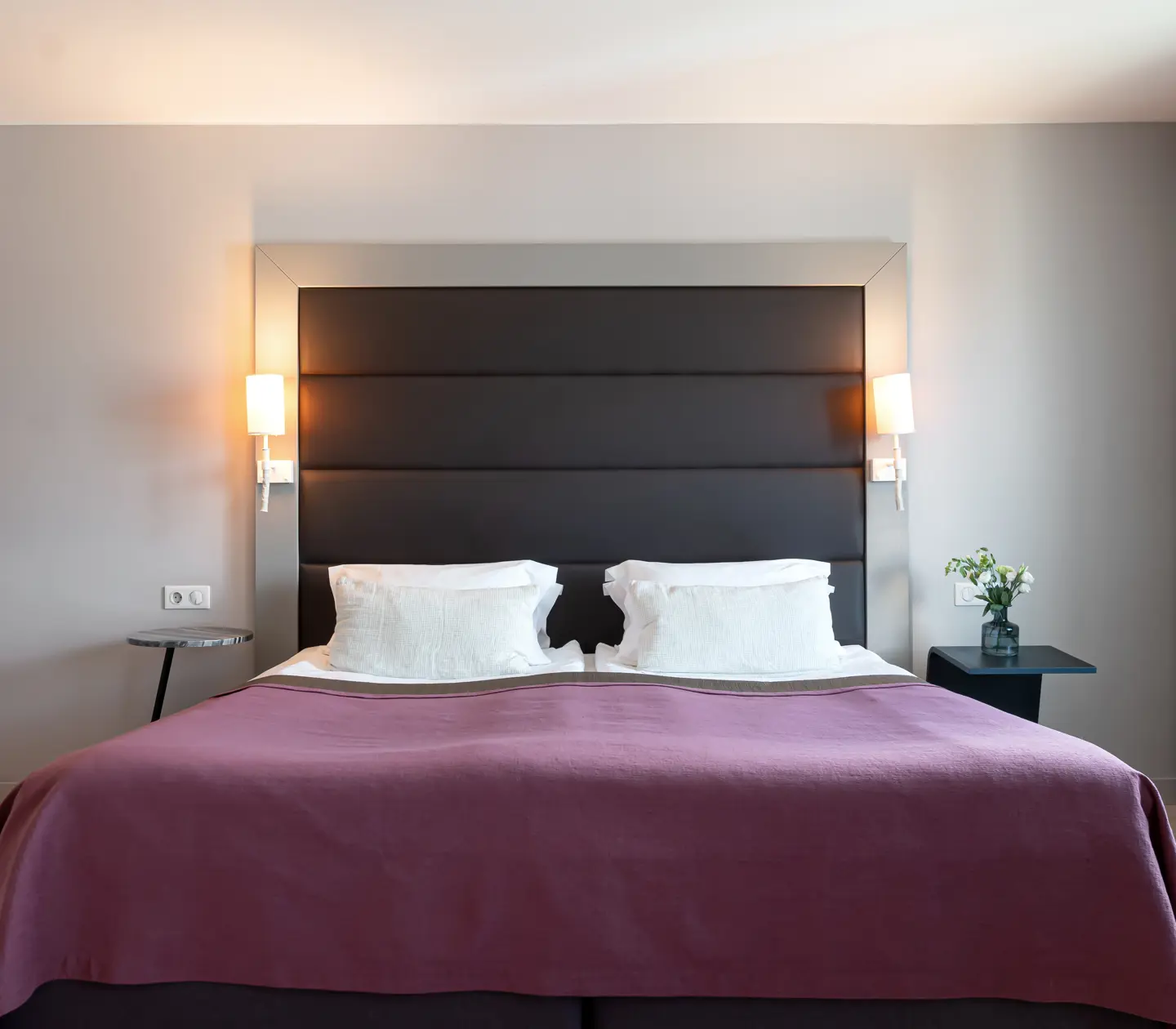 Ljust hotellrum med stor dubbelsäng