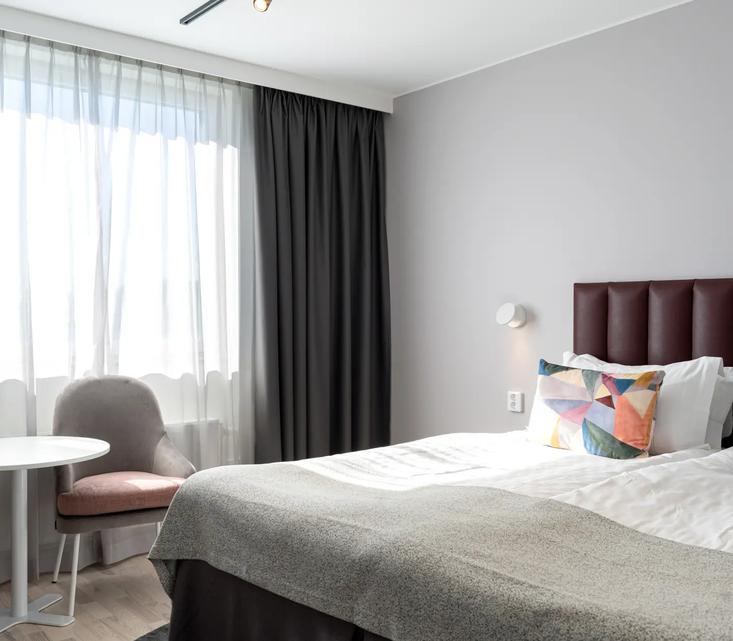 Hotellrum med dubbelsäng och fåtöljer