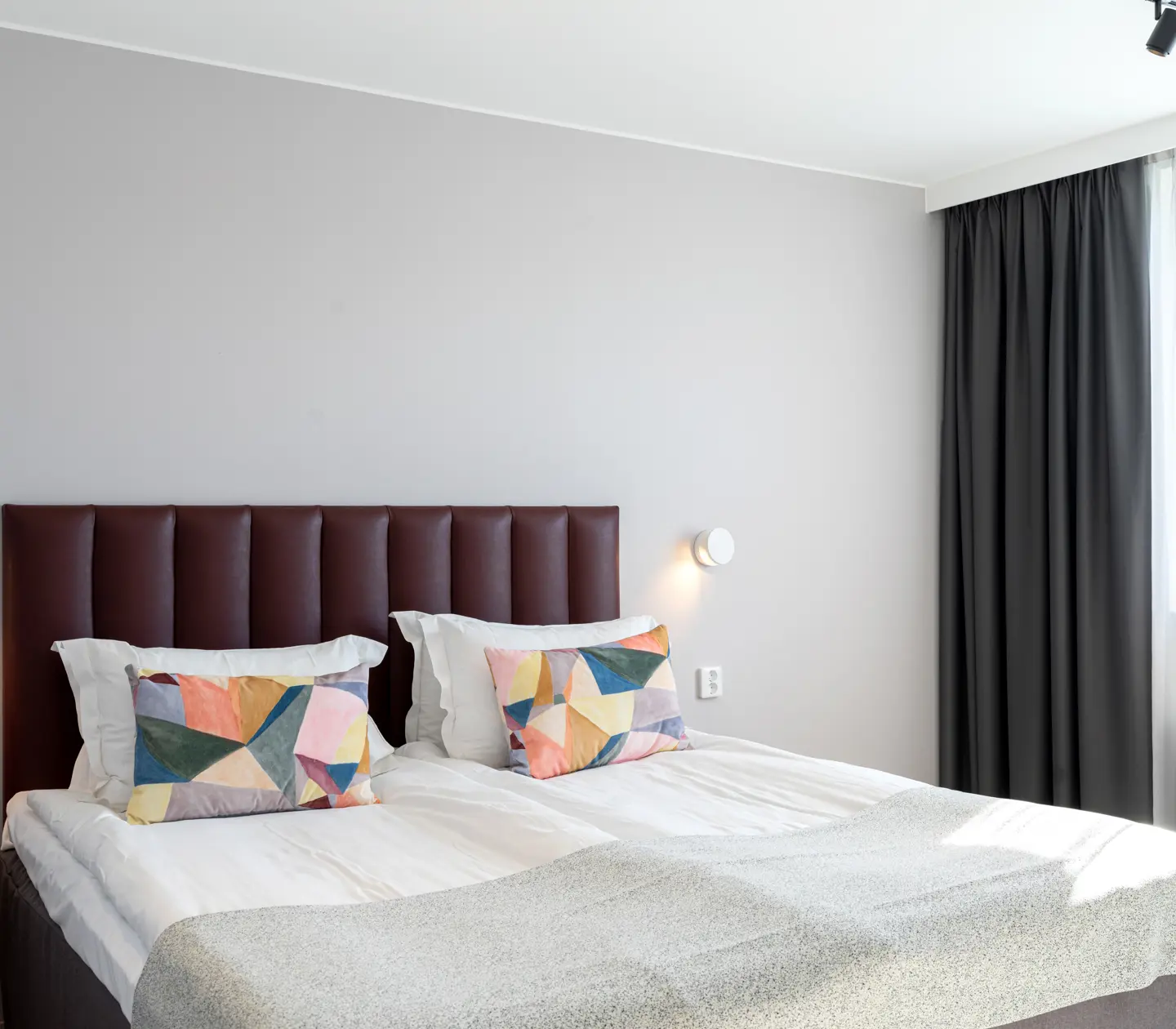 Hotellrum med dubbelsäng och färgglada kuddar