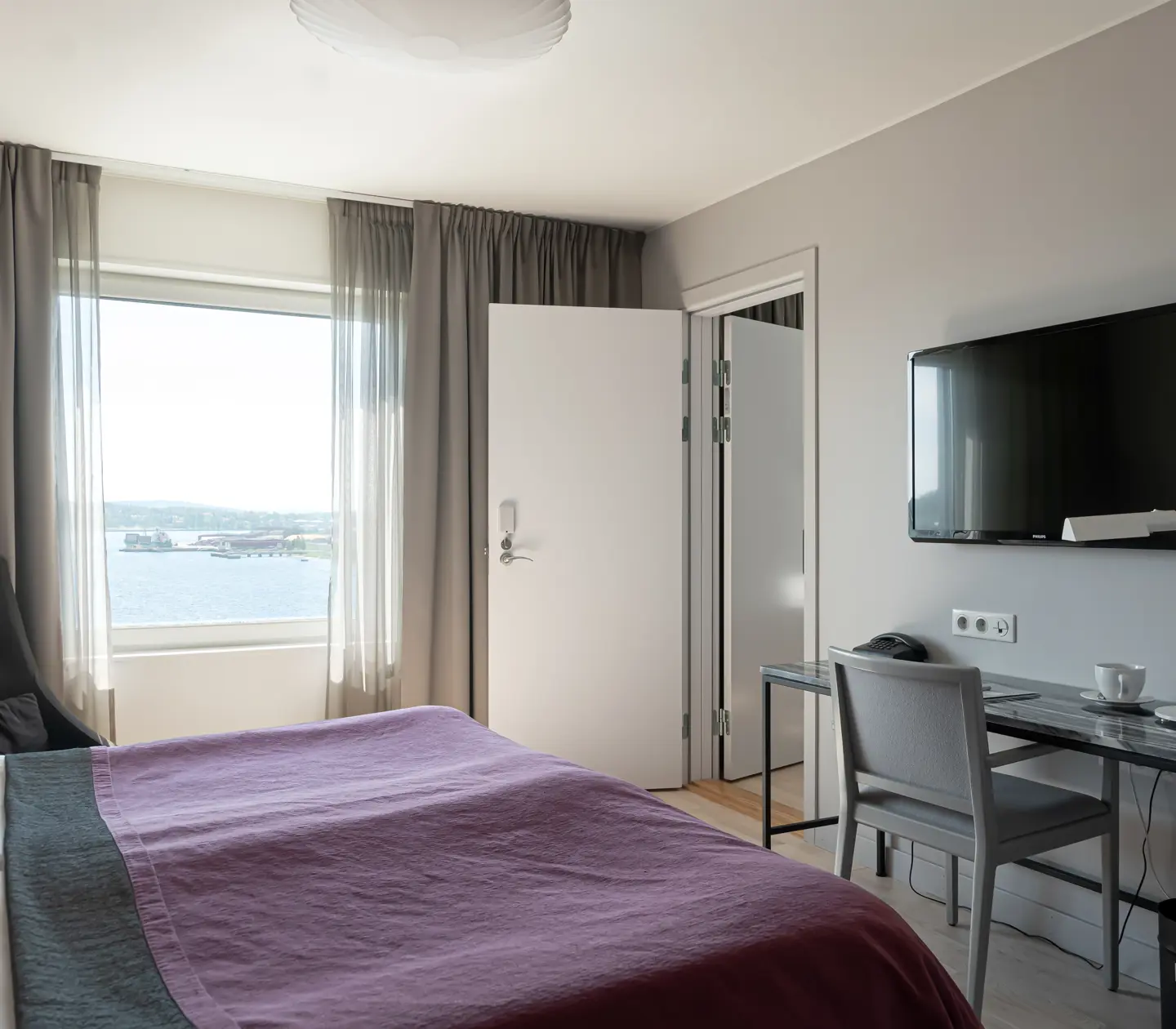 Svit med dubbelsäng, skrivbord, tv och fönster