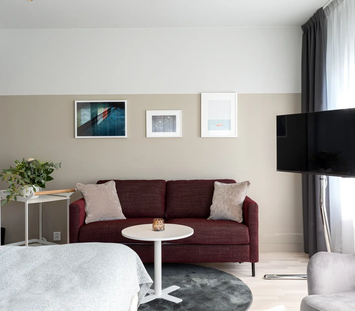 Hotellrum med soffa, tv och tavlor