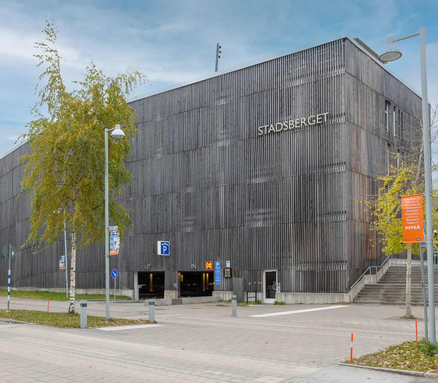 Grått parkeringshus med in och ut-skyltar och "Stadsberget"