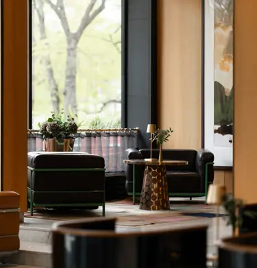 Hotellobby med loungemöbler, dekorationer och stora fönster