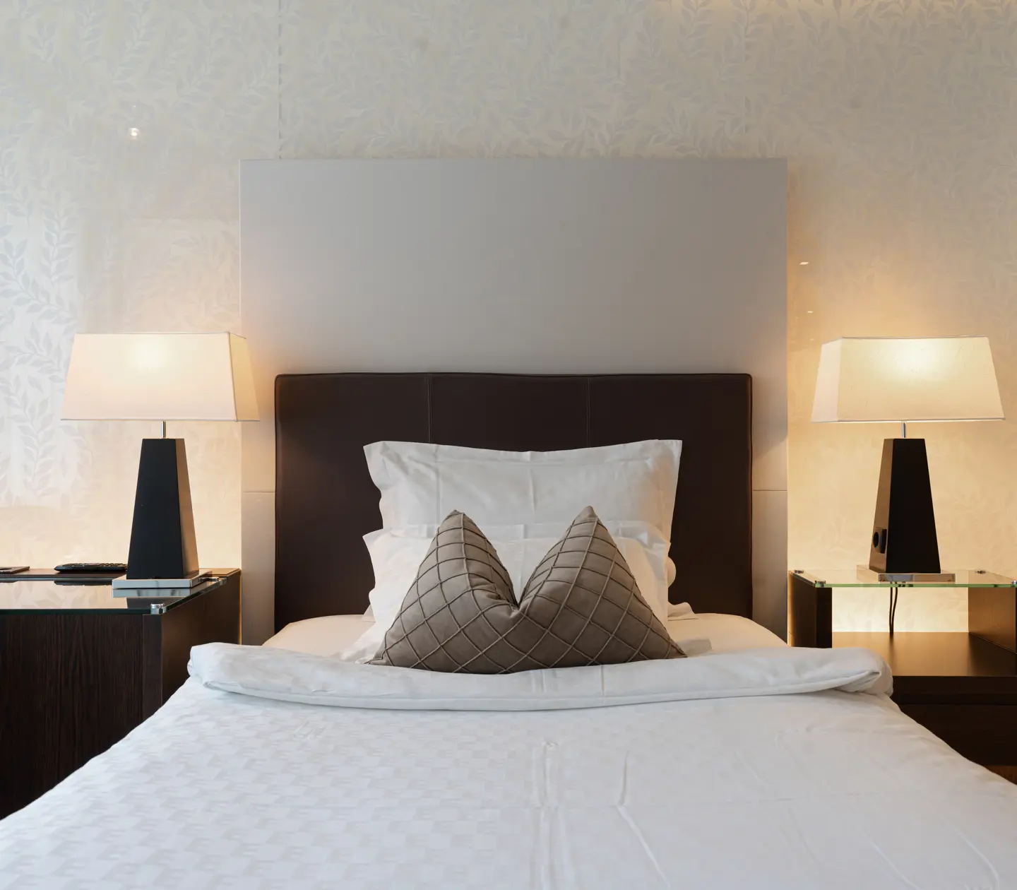 Ljust hotellrum med säng, skrivbord och dörr in till badrum